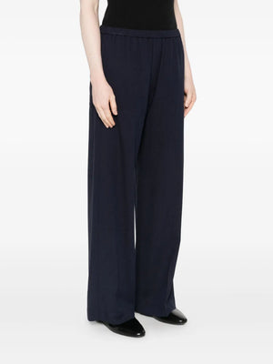 Close up of Fluid Winter Trousers in Navy, highlighting the soft fabric blend of 90% viscose and 10% wool by TOTEME.