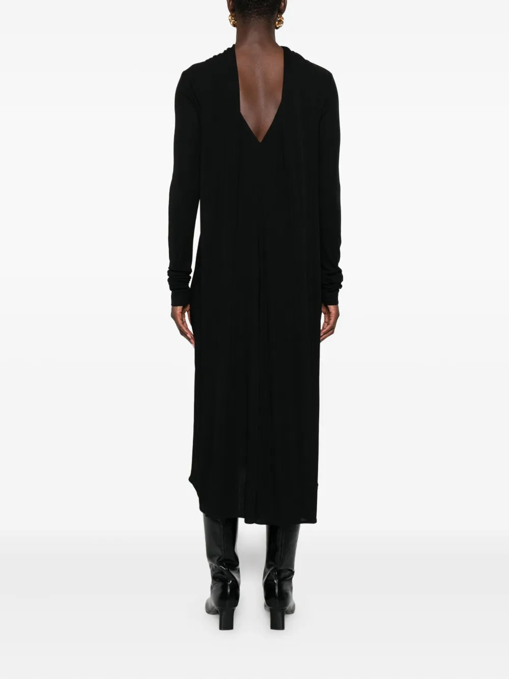 Side view of the black Cocoon Cape Dress by TOTEME, emphasizing its slightly dipped hem and cape-like design.