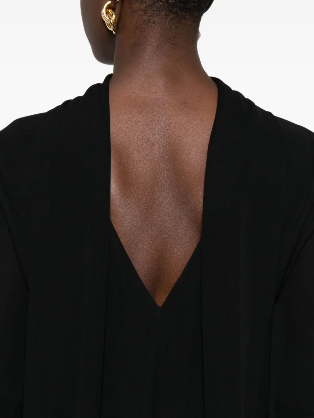 Back view of TOTEME's Cocoon Cape Dress in Black, illustrating the elegant cape back panels and stylish silhouette.