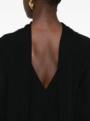 Back view of TOTEME's Cocoon Cape Dress in Black, illustrating the elegant cape back panels and stylish silhouette.