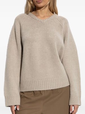 Model wearing Oia Sweater in Sand with a slightly curved back hem, styled for a casual look.