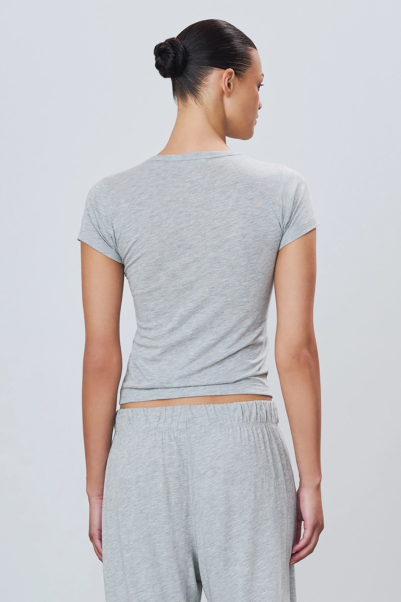 Model wearing Fitted Crewneck Short Sleeve T-shirt in Heather Grey, demonstrating the stylish and casual appeal of this fitted crewneck t-shirt.