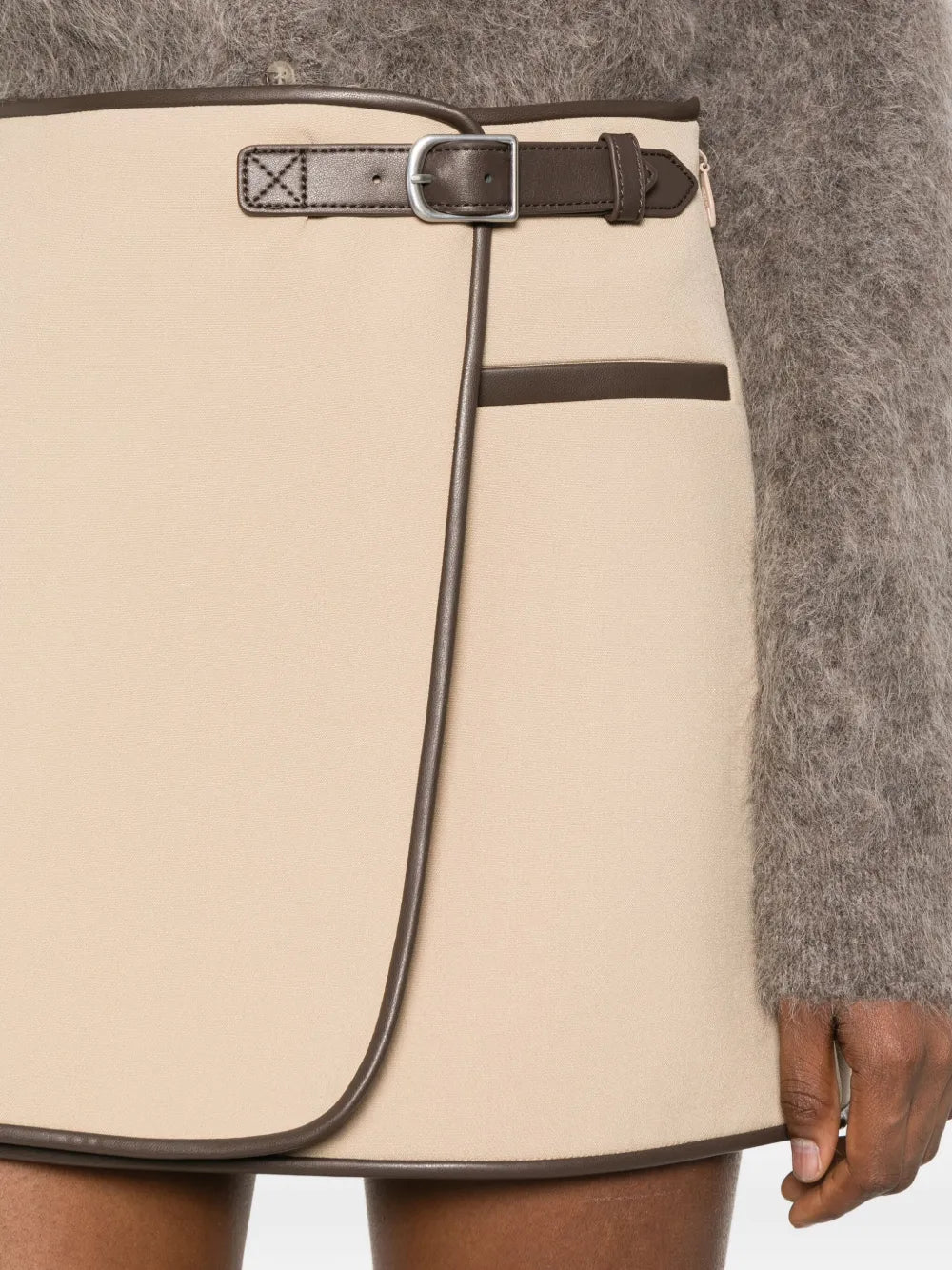 Flat lay of Simkhai's Sheridan Mini Skirt in Light Camel against a stylish backdrop.