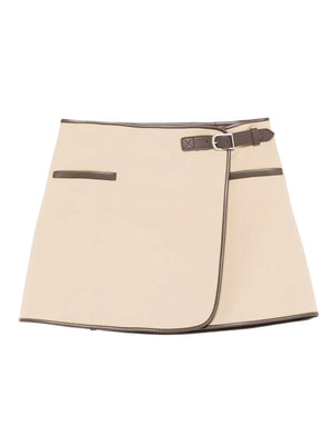 Sheridan Mini Skirt in Light Camel showcasing its stylish wrap-over style and faux leather trim by Simkhai.