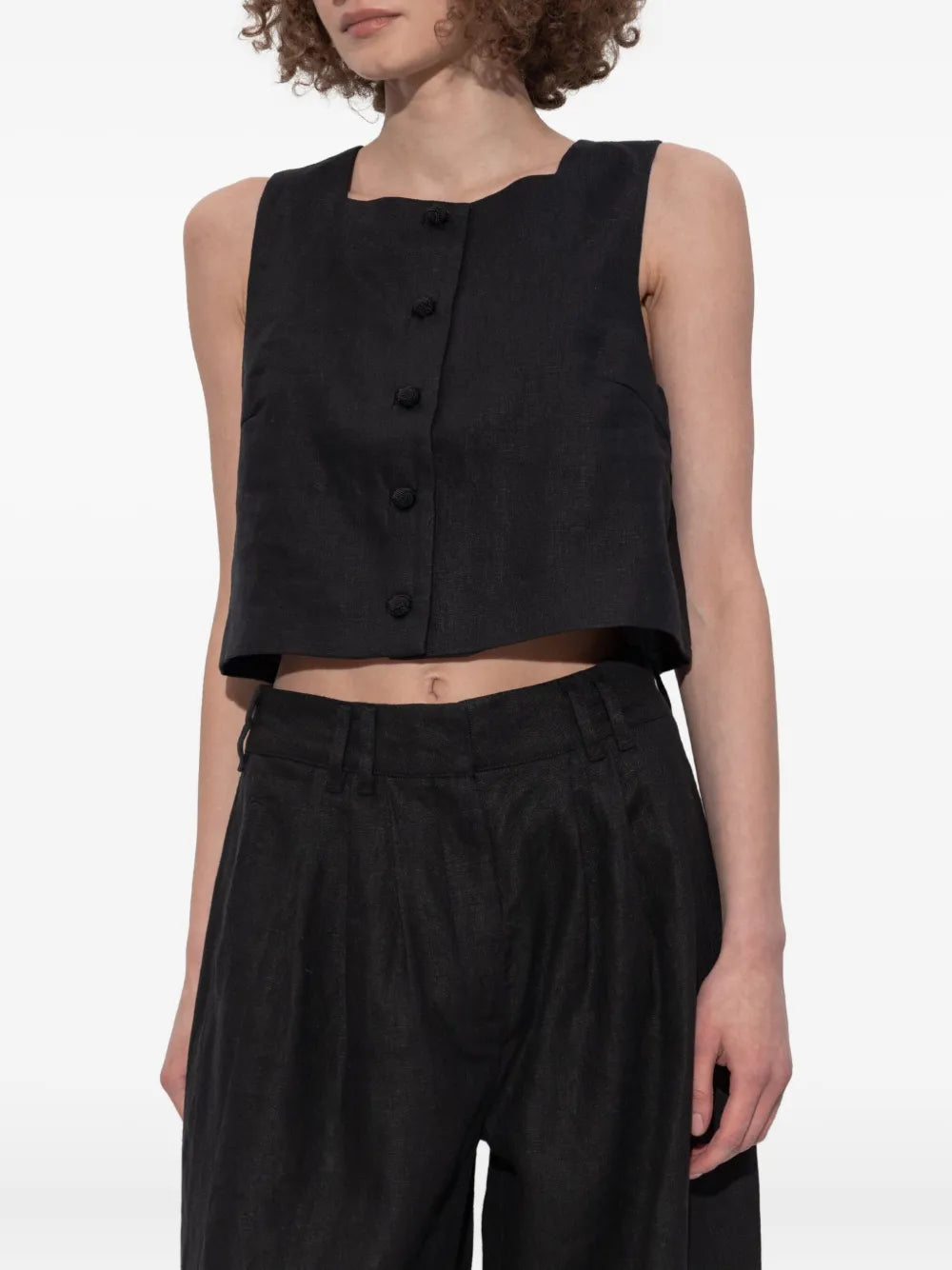 Model wearing the Rio Top in Black, showcasing this trendy black crop top styled with jeans.