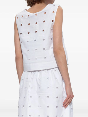Model wearing the Peggy Top in Vintage White with intricate laser cut embroidery for a chic look.