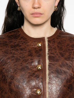 Flat lay of the Zanie Short Shearling Coat in Vintage Whiskey showcasing its luxurious lamb fur and handcrafted quality.
