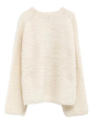 Flat lay of the Boxy Boucle Knit in Milk, emphasizing its luxurious alpaca-blend fabric and elegant design.