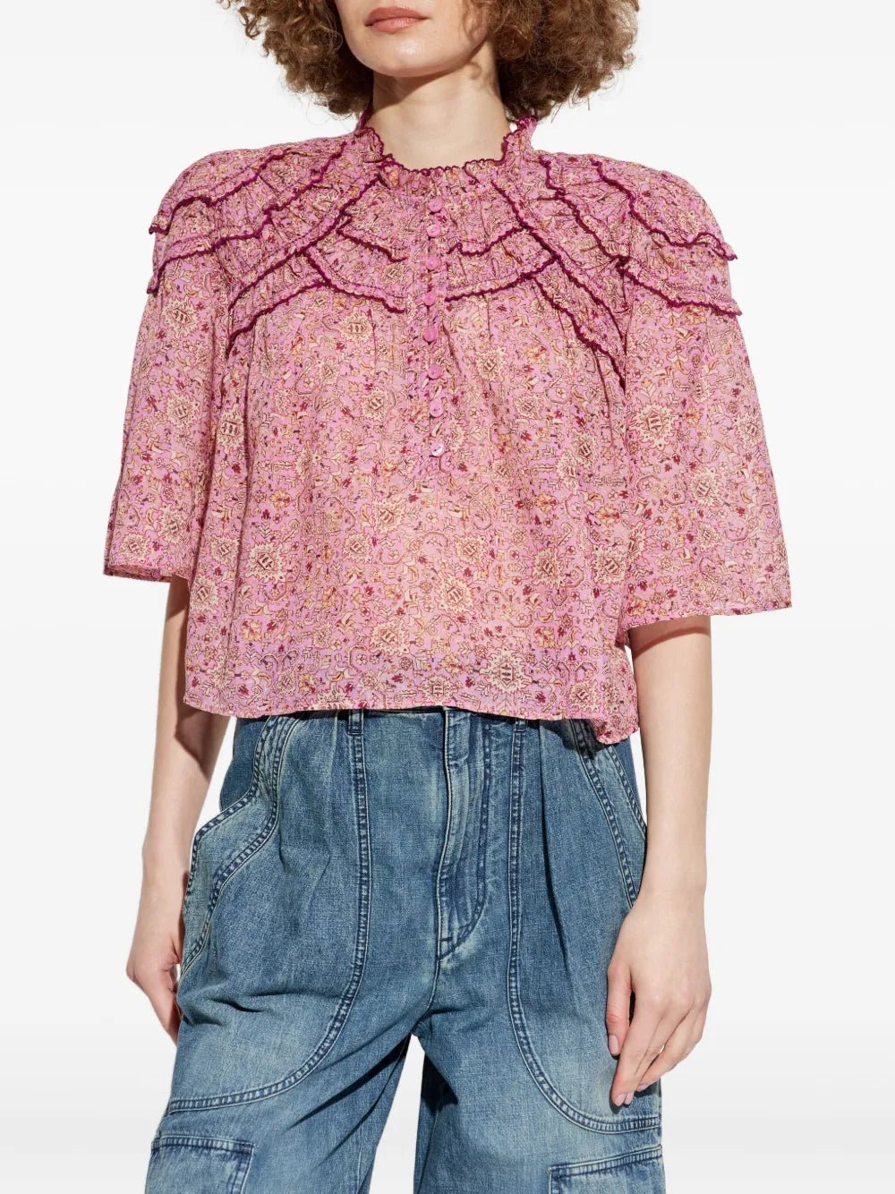 Model wearing the Carmen Top in Pink with short loose sleeves and a flared cut.