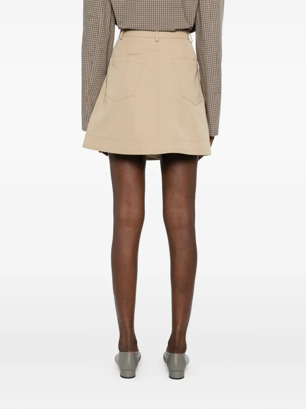Back view of the Inge Mini Skirt in Beige by Nanushka, highlighting its A-line silhouette.