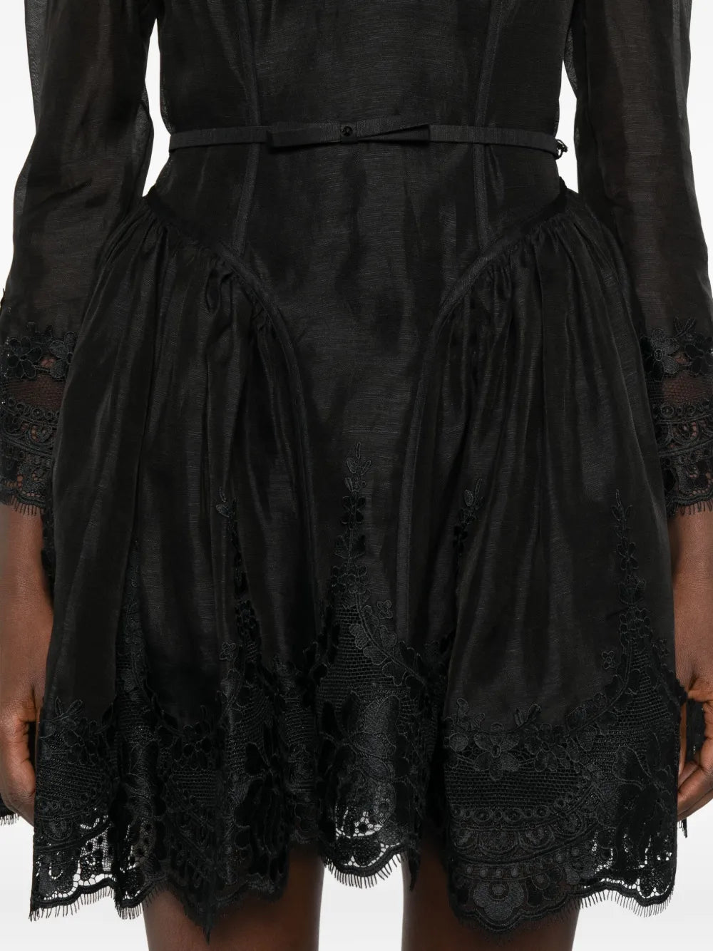 Full length image of the Hypnotic Lace Trim Mini Dress in Black against a stylish backdrop, showcasing its chic style.
