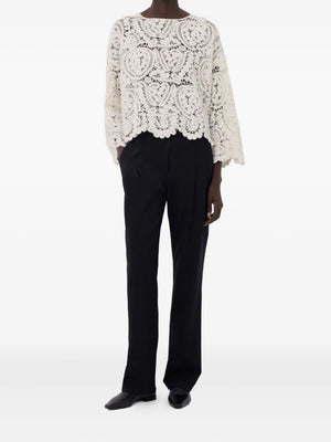Model wearing the Arold Sweater in Ivory, highlighting the elegant boat neck and long sleeves.