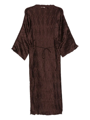 Tralaido Dress in Coffee Brown by Malene Birger, showcasing the shimmering plissé fabric and loose fit design.