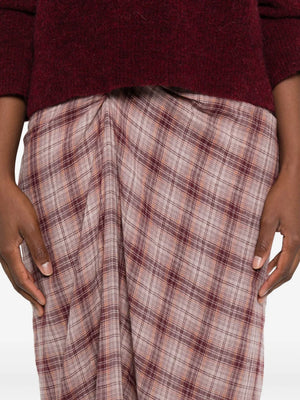 Side angle of the Nicole Skirt in Rosewood, illustrating its flowing fabric and checkered pattern in a chic setting.