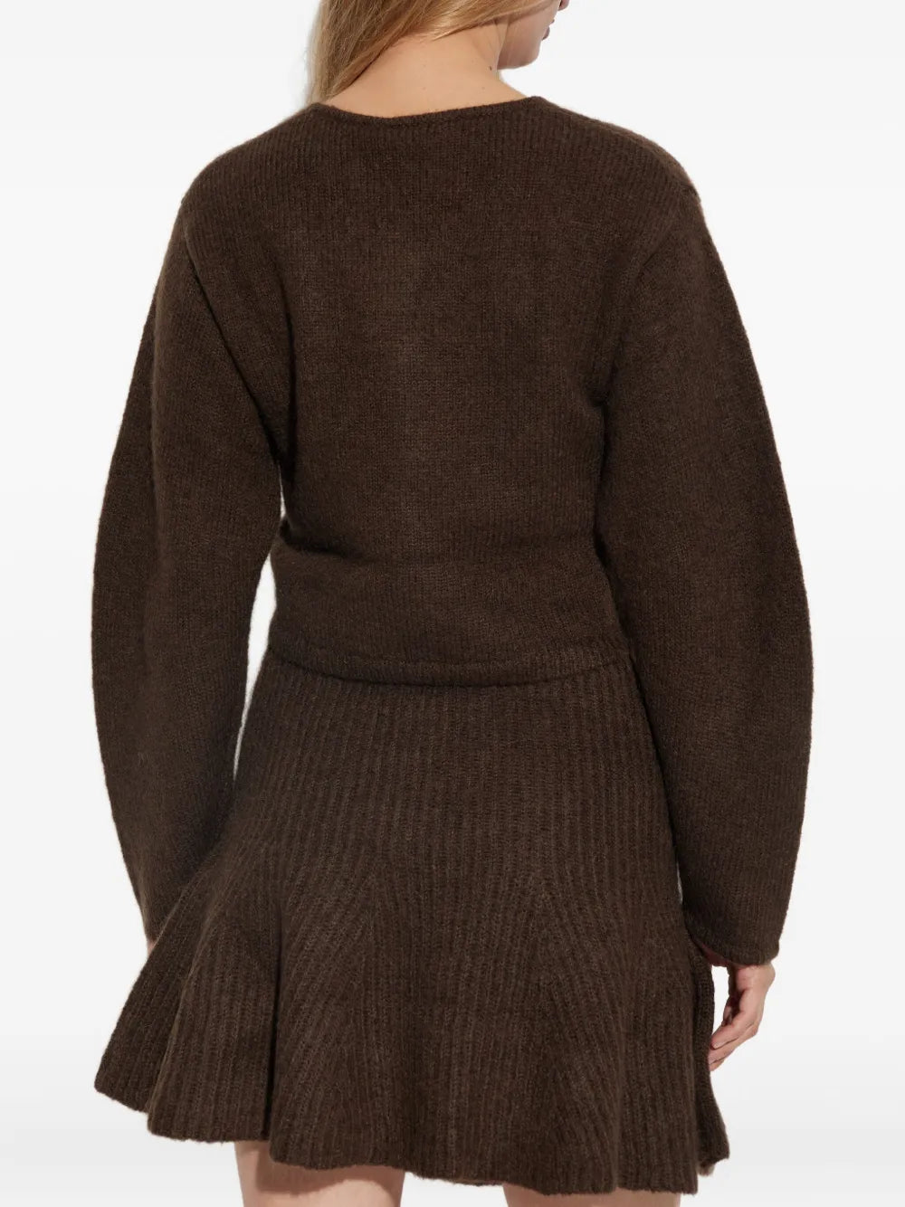 Model wearing the Zharea Cardigan in Dark Mahogany against a cozy backdrop, representing classic winter fashion.