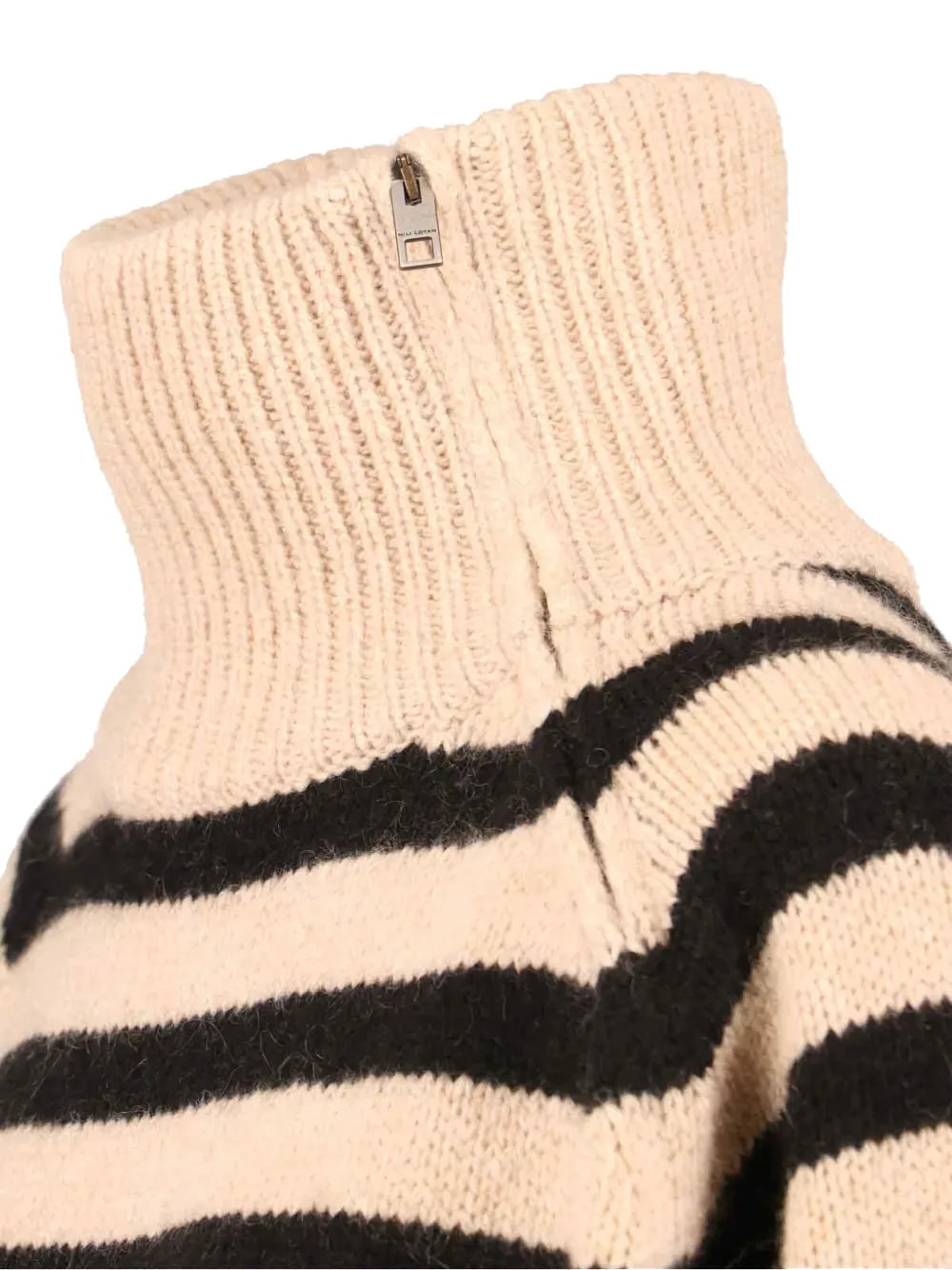 Detailed view of the rib trim at the hem and sleeve of the Raelynn Cashmere Sweater in Parchment/Black.