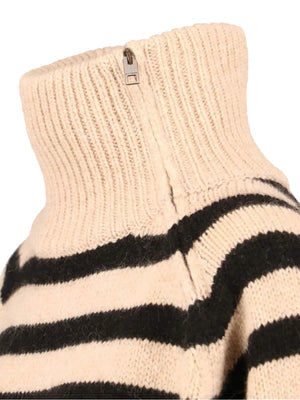 Detailed view of the rib trim at the hem and sleeve of the Raelynn Cashmere Sweater in Parchment/Black.