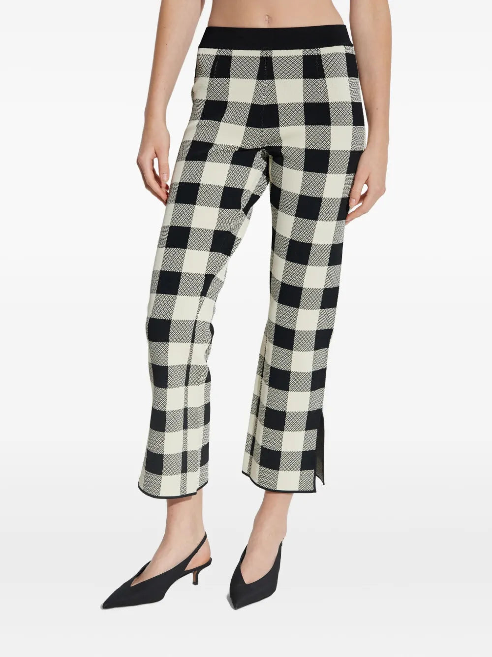 Side view of the Pippa Pants in Heritage Plaid styled with a chic black top.