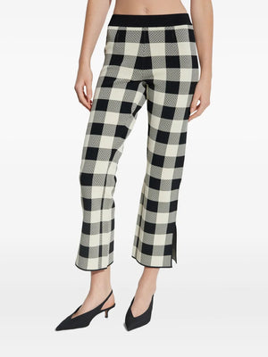 Side view of the Pippa Pants in Heritage Plaid styled with a chic black top.