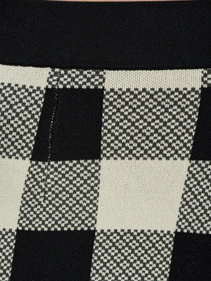 Rear view of the Pippa Pants in Heritage Plaid demonstrating their unique kick-flare hem.