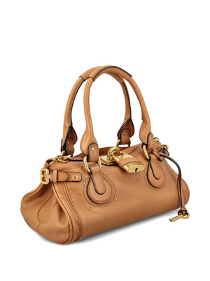 Close-up of Chloé's Paddington Bag in Mustang Brown, highlighting the grainy texture and C-shaped buckles.