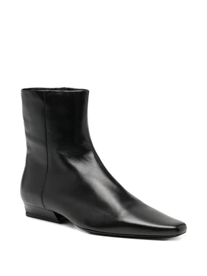 Close-up view of Wally Flat Ankle Boot in Black showcasing the luxurious lamb leather material.