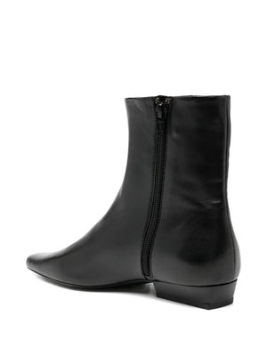 Wally Flat Ankle Boot in Black by Staud modeled with casual outfit highlighting its sleek design.