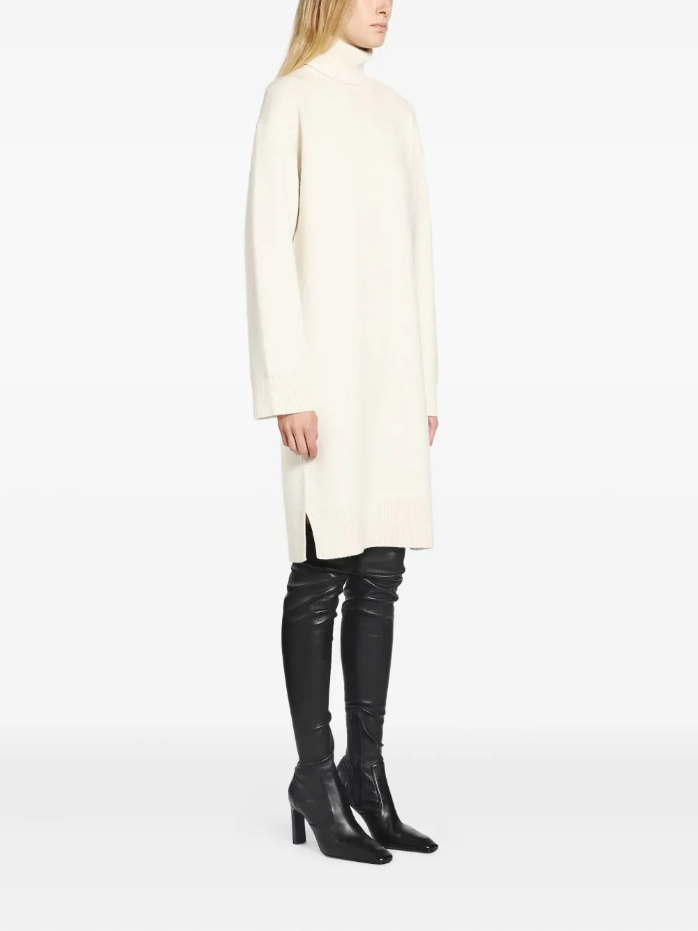 Model wearing the Broad Turtleneck Dress in Milk paired with high boots, perfect for winter fashion.