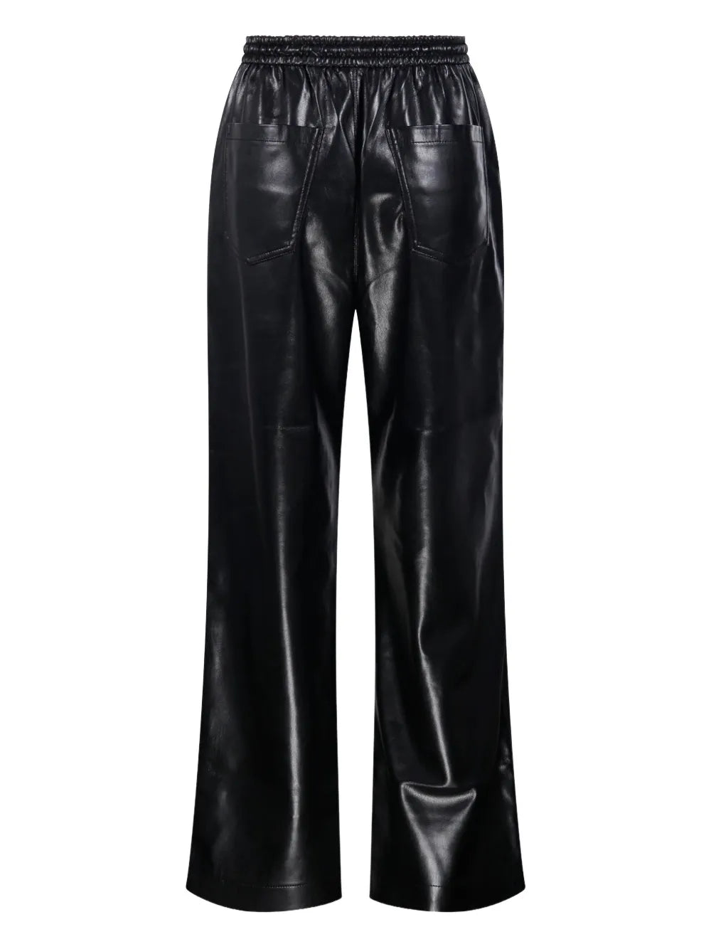 Model wearing Nanushka Calie Trousers in Black in an urban setting, paired with chic apparel.