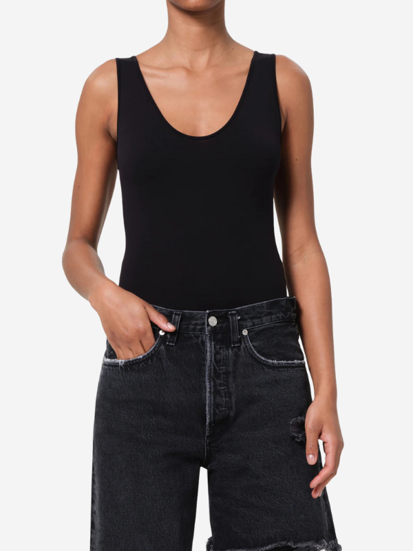 Agolde Tora Tank Bodysuit in Black styled with denim for a casual look.