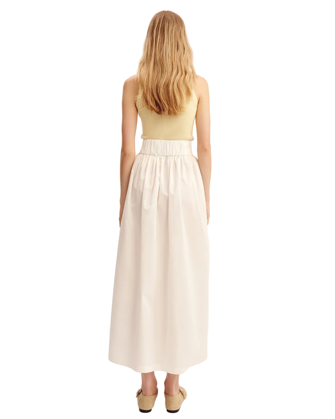 Model wearing Oscar Skirt in Cream - elegant cream midi skirt with high-rise waist and side pockets.