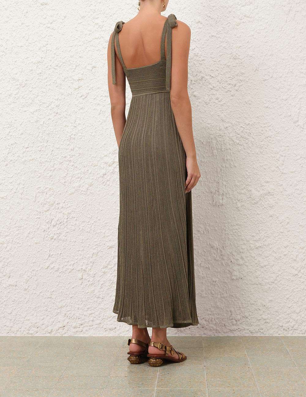 Side view of the Wanderlust Metallic Maxi Dress in Metallic Olive, emphasizing the styling of the pleated design and self-tie straps.