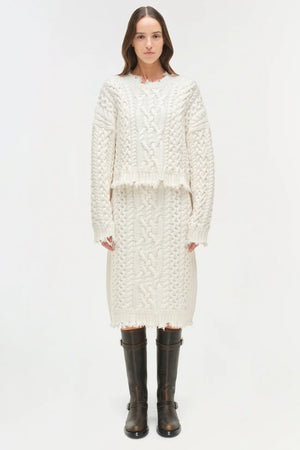 Model wearing the Felix Knit Cropped Sweater in Ivory, styled with denim for a casual look.