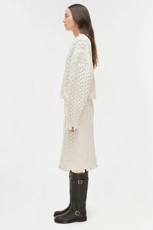 Flat lay of the Felix Knit Cropped Sweater in Ivory on a textured background, highlighting its knitted design.