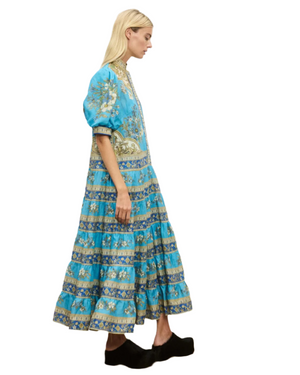 Back view of the Cassie Tiered Midi Dress in Blue, demonstrating its stylish puff sleeves and cinched waist with a self-covered belt.