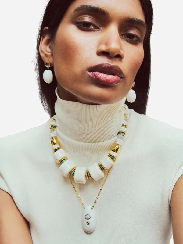 Flat lay of the Granada Necklace in Blanco by Lizzie Fortunato, featuring gold-plated brass and aqua crystal quartz with a chic aesthetic.