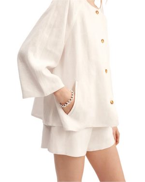 Stylish presentation of the Olivia Blouse in Ivory highlighting the soft linen fabric, a must-have ivory blouse for women.