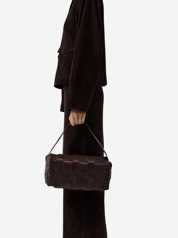 A close-up of the Woven Envelope Slim Tote in Chocolate, highlighting the flap closure and hidden magnetic fastening.