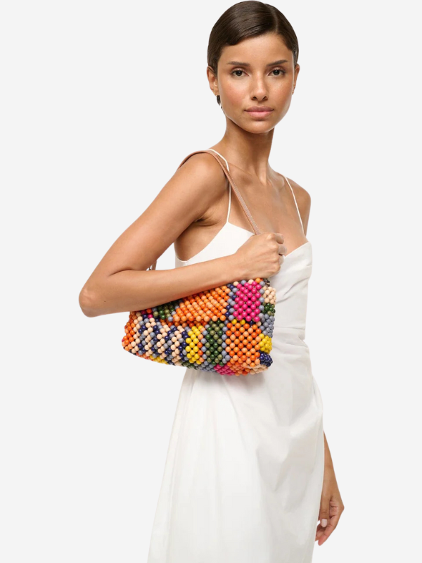 The Staud Timmy Shoulder Bag in Multi Bayadere Stripe with a view of its custom logo leather patch on the back.