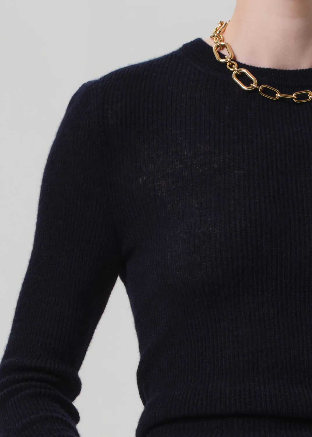 Side angle of the Alessia Crewneck Sweater in Navy worn with tailored trousers, demonstrating versatile styling options.