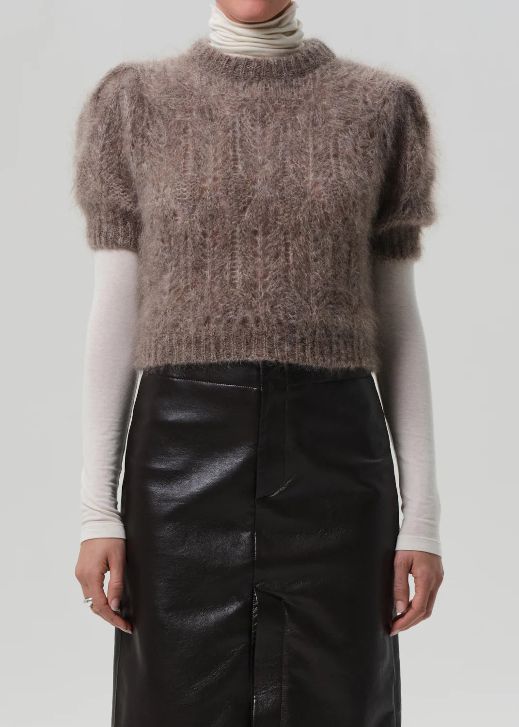 Model wearing Odette Puff Sleeve Sweater in Mushroom, demonstrating its chic layered look under tailoring.