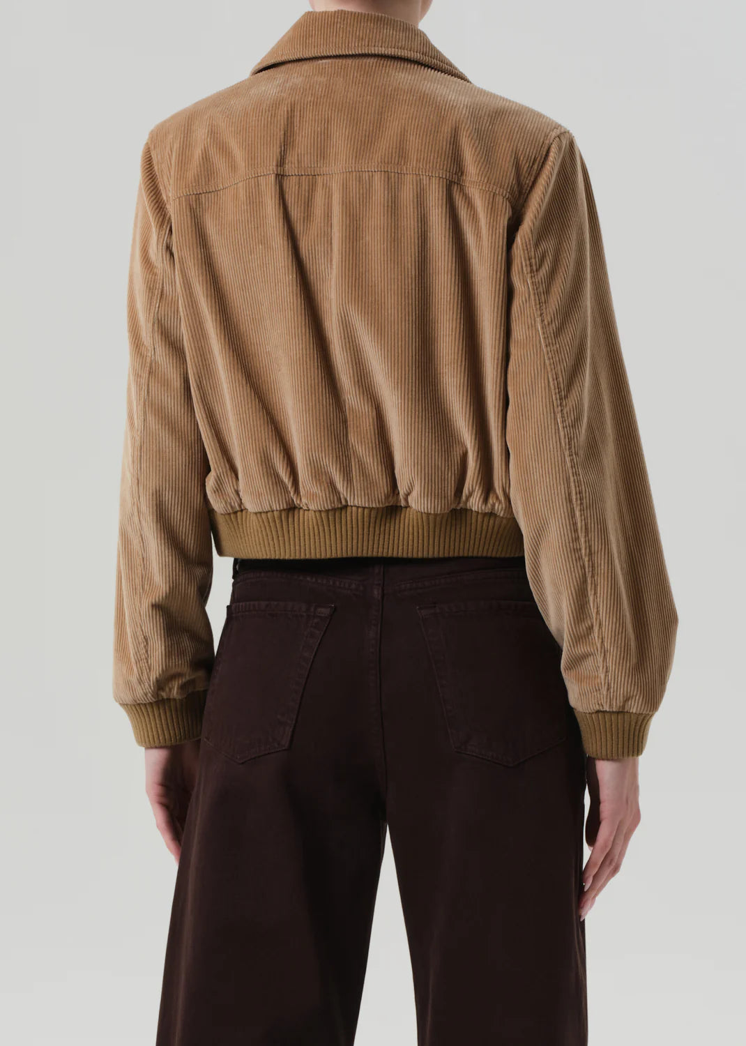 The Lola Eve Bomber in Amber beige, pairing nicely with tonal denim for a chic appearance.