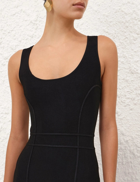 Full-length shot of the Hypnotic Sculptural Midi Dress in Black worn at an outdoor event.