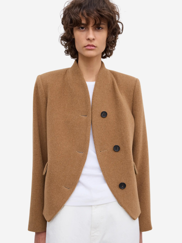 The Short Curved Jacket in Camel displayed on a hanger, fully lined and made from high-quality materials.