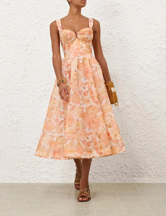 Model wearing the Rebellion Drape Midi Dress in Golden Bloom, radiating elegance at a summer gathering.