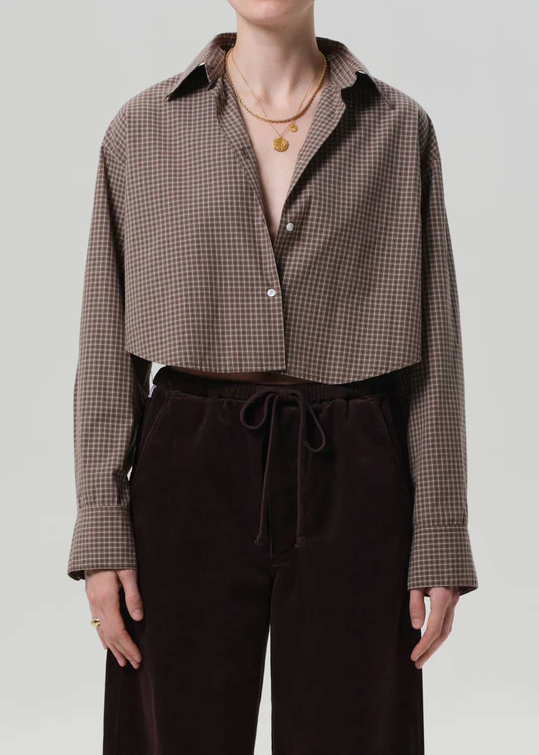 Model wearing the Ana Cropped Shirt in Heritage Plaid, styled with high-rise denim for a trendy look.