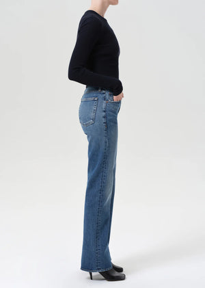 A model wearing Agolde Kick Boot Jean in Curve, paired with a slim knit top for a trendy look.
