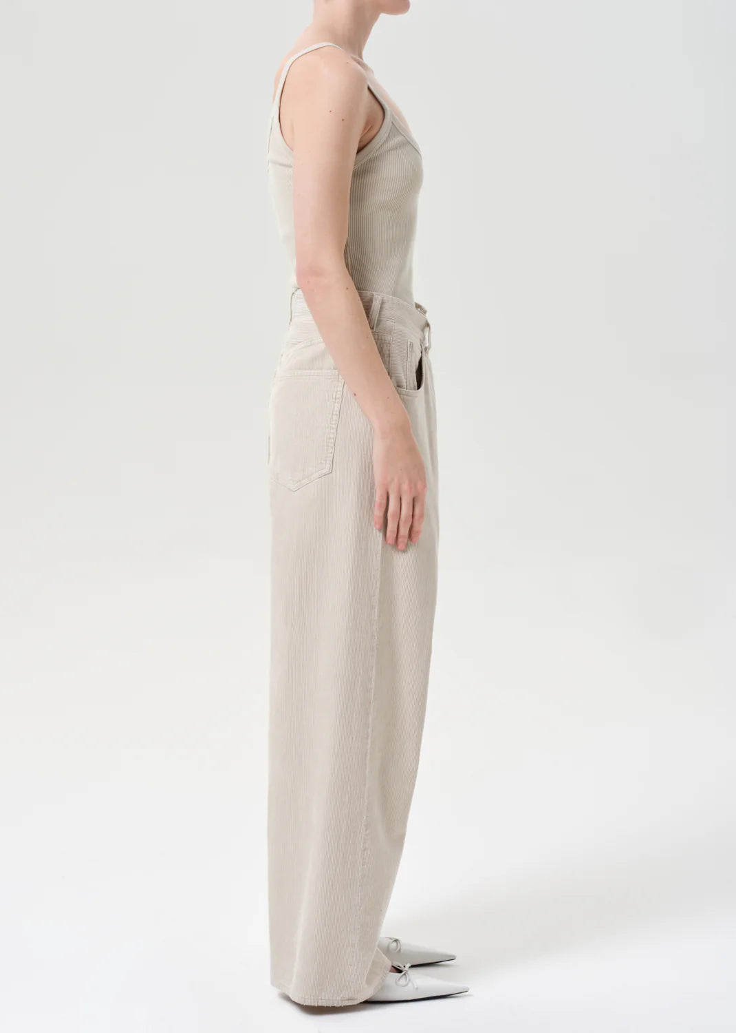 The Agolde Vana Fold Corduroy in Rice Grass worn with a casual tank top for a stylish look.