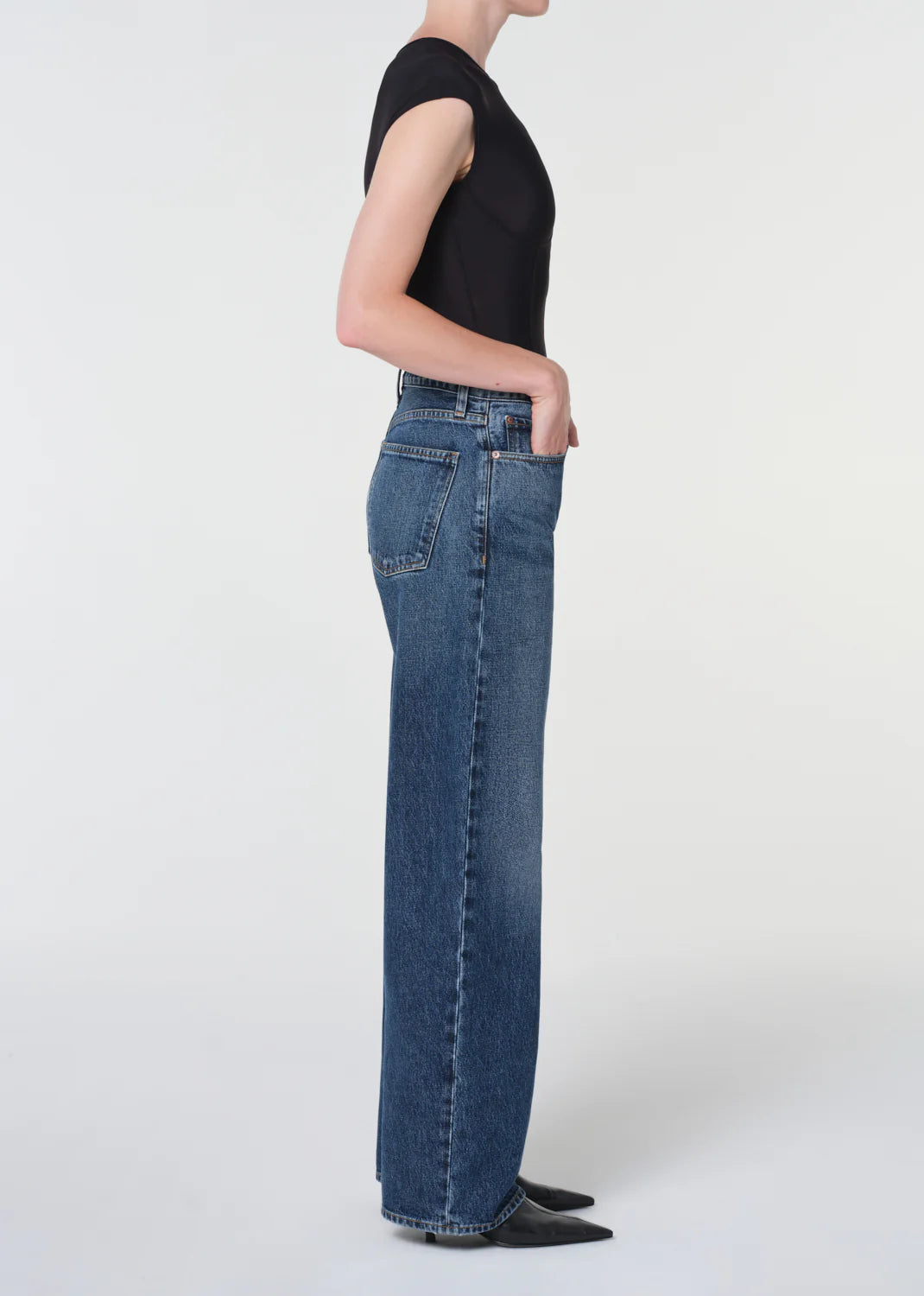 Model wearing Agolde Arc Jean 32" in Shortwave paired with a fitted top, displaying the denim's lived-in character.
