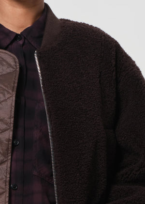 Iona Skye Jacket in Chocolate draped elegantly over a chair, showcasing its rich color and soft fabric.